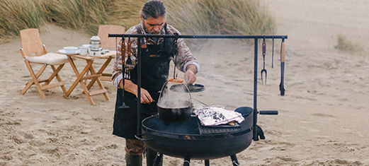 Person cooking outdoors with Barebones products