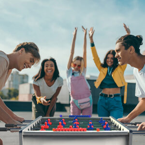 Group watching two people play foosball