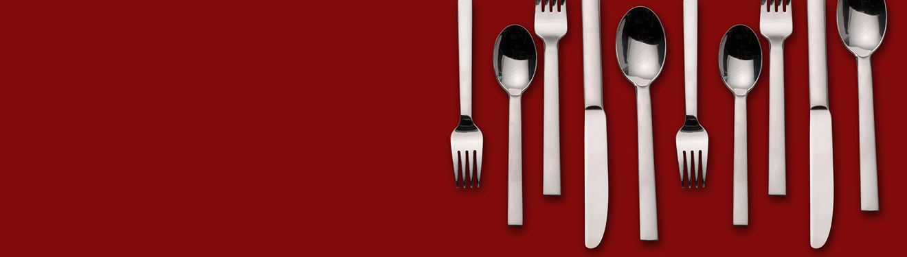 Silverware laid out on a red background