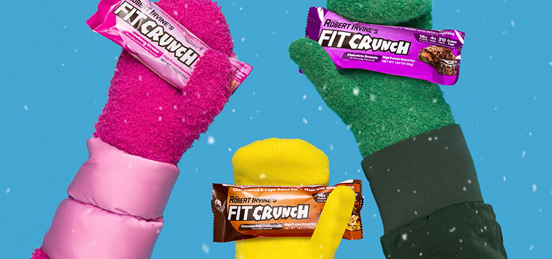 People wearing mittens holding FitCrunch bars