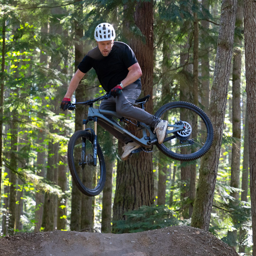 Guy jumping a dirt ramp on bike